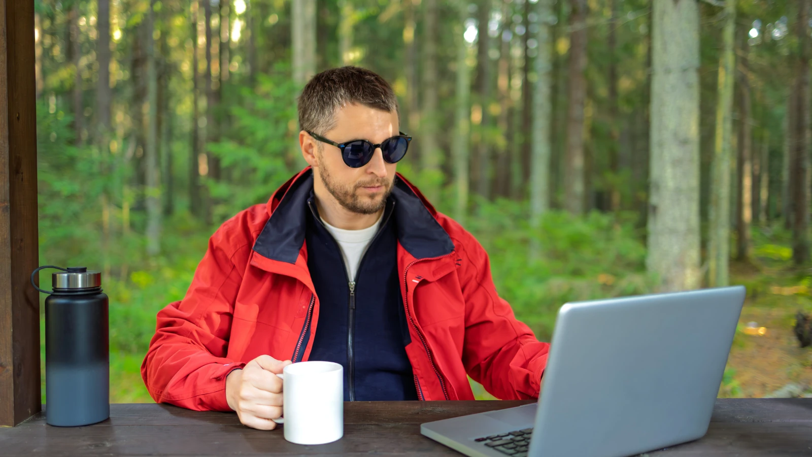 Digital nomad working on a laptop in a forest setting