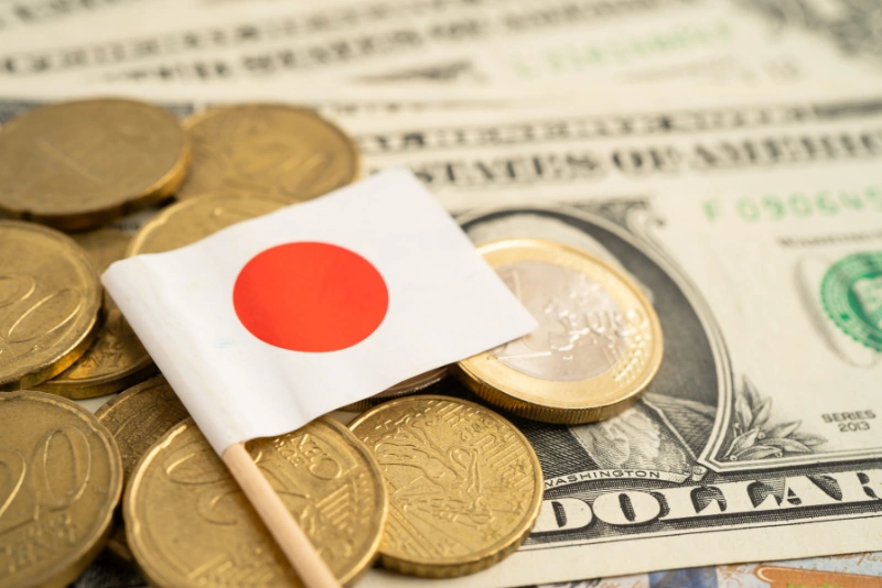 Japan flag with foreign currency coins for FEIE versus FTC planning