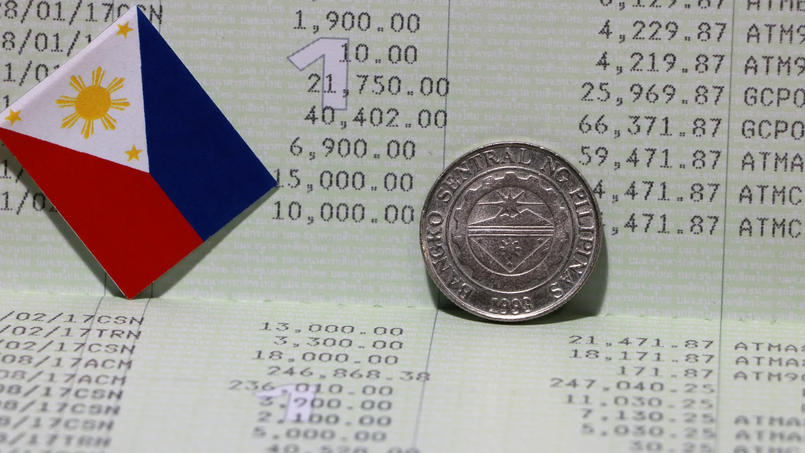 Philippines flag with coin and bank statement for property ownership tax planning