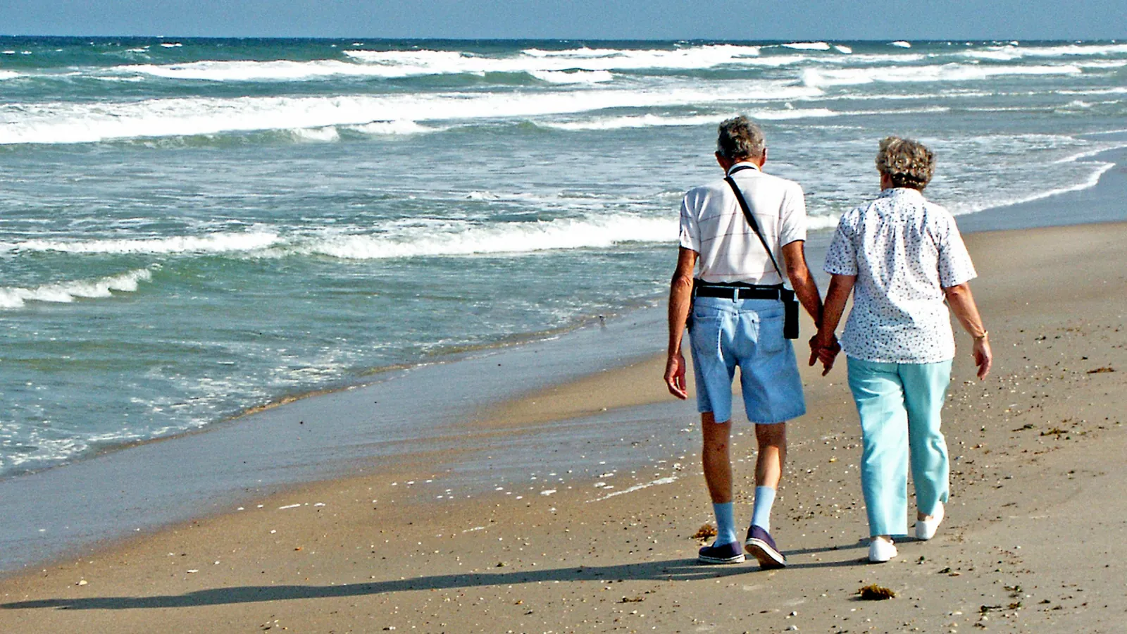 Retired couple walking on the beach