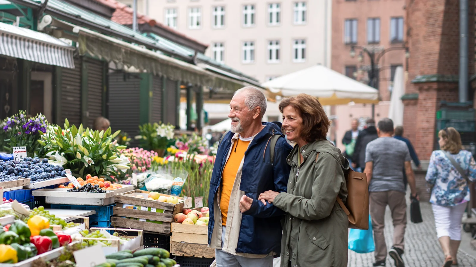 Retired couple shopping at an outdoor farmers market